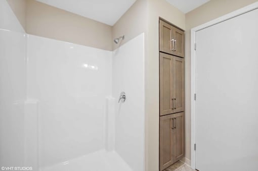 A white bathroom with a wooden medicine cabinet.