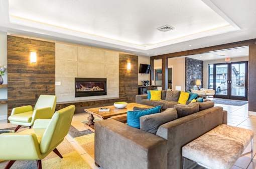 a living room with couches and chairs and a fireplace at Corso Apartments, Missoula, MT