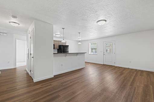 A kitchen with white cabinets and a wooden floor.
