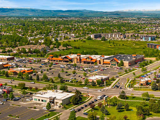 A large parking lot is surrounded by buildings and a road at The Beaumont Apartments, Montana