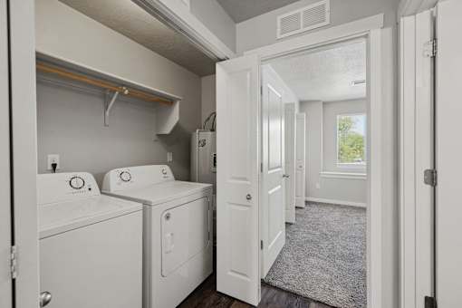 a washer and dryer in a laundry room with a window and a door