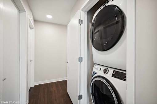 A white washing machine is in a small laundry room.