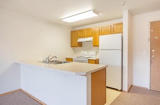 a kitchen with a white counter top and a refrigerator