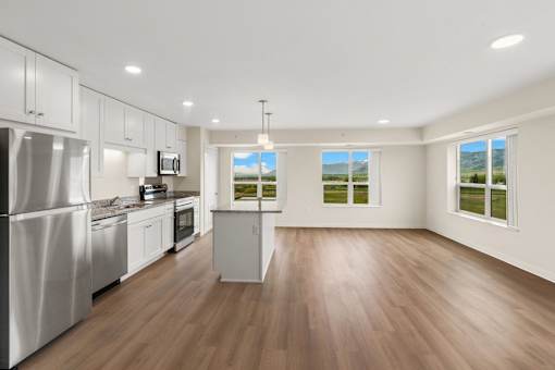 A kitchen with white appliances and wooden floors at The Beaumont Apartments, Montana, 59715