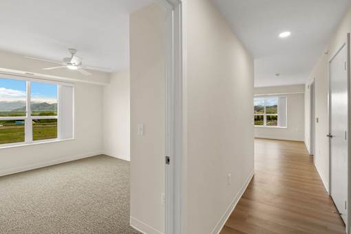 A room with a carpet floor and a ceiling fan at The Beaumont Apartments, Bozeman
