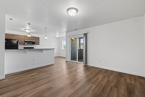 A spacious room with wooden flooring and a television on the counter.