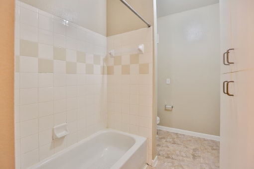 a bathroom with white tile and a white bathtub at The Vineyards of Colorado Springs, Colorado Springs, CO