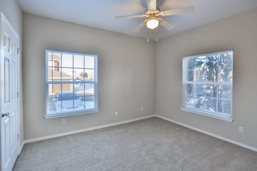 a bedroom with two windows and a ceiling fan at The Vineyards of Colorado Springs, Colorado Springs, CO