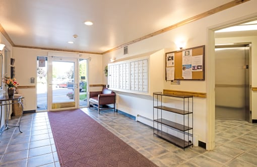 a lobby with a chair and a desk and a door
