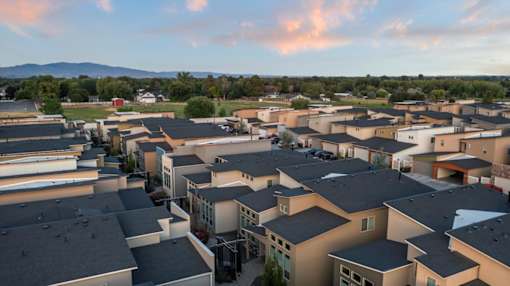 A large group of houses with a mountain in the background. at Verraso Village Apartments, Meridian, ID