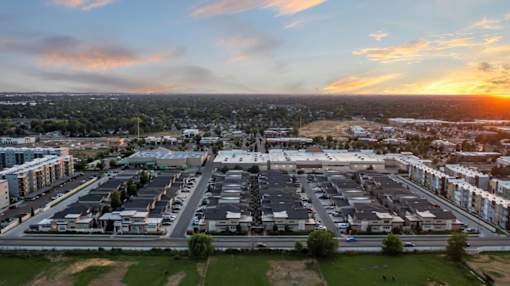 A sunset view of a residential area with houses and apartment buildings. at Verraso Village Apartments, Idaho