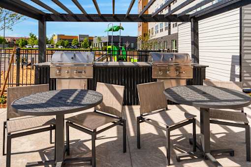 A patio with a table and chairs under a roof at The Beaumont Apartments, Bozeman, Montana 59715