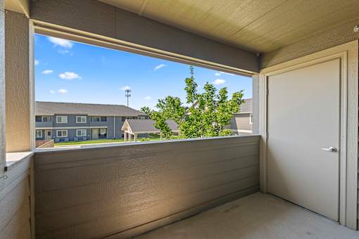 A balcony with a view of a building and trees.
