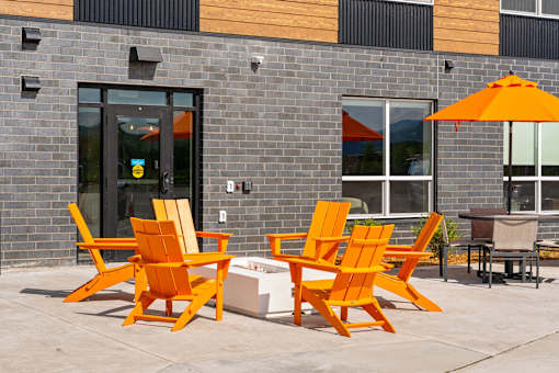 A set of orange chairs and a table are placed at The Beaumont Apartments, Bozeman, 59715