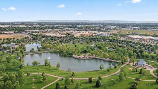 A beautiful aerial view of a park with a lake and a fountain. at Verraso Village Apartments, Meridian, ID