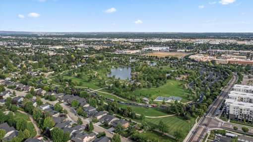 A suburban area with a lake and a road with cars. at Verraso Village Apartments, Idaho