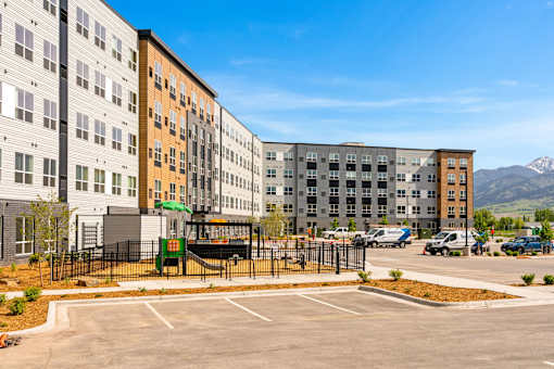 A parking lot in front of a multi-story apartment building at The Beaumont Apartments, MT 59715
