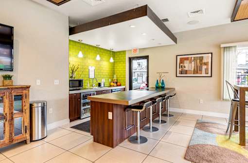 a kitchen with a bar with stools and a tv at Corso Apartments, Missoula, MT