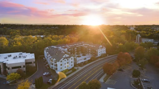 an aerial view of a building with the sun setting behind it at River Walk Apartments, Boise, Idaho