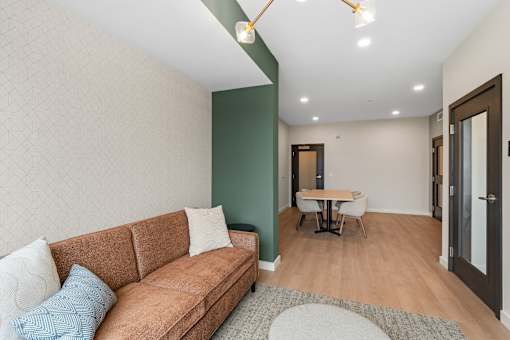 A living room with a brown couch and a small table at The Beaumont Apartments, MT 59715