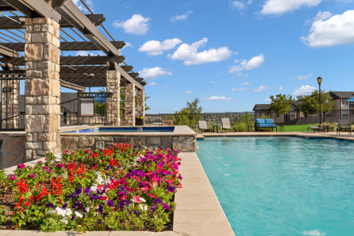 a swimming pool with flowers on the side of a building at The Vineyards of Colorado Springs, Colorado Springs, 80920