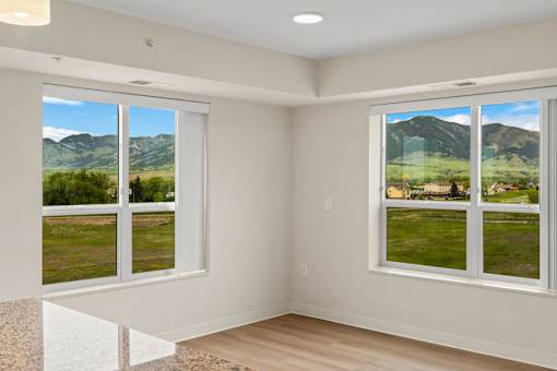 A room with a view of a mountain range through the windows at The Beaumont Apartments, Bozeman, Montana 59715