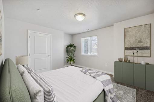 a white bedroom with a white bed and a green couch