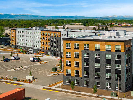 A parking lot in front of a multi-story building at The Beaumont Apartments, Bozeman, 59715