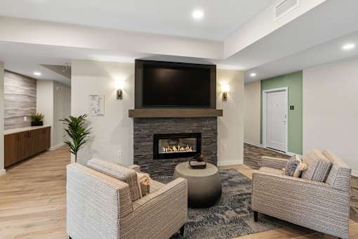 A modern living room with a fireplace and a flat screen TV mounted above it at The Beaumont Apartments, Bozeman, 59715