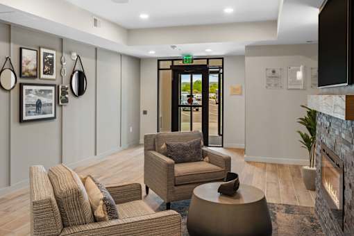 A living room with a brown couch, a chair, and a coffee table at The Beaumont Apartments, Bozeman, MT