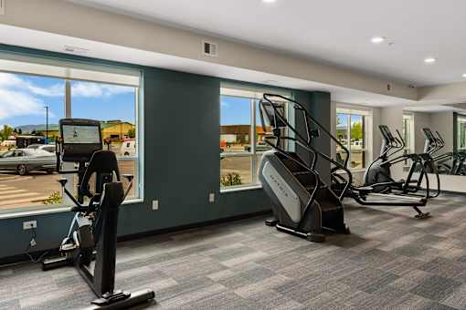 A gym with treadmills, elliptical machines, and a rowing machine at The Beaumont Apartments, Montana, 59715
