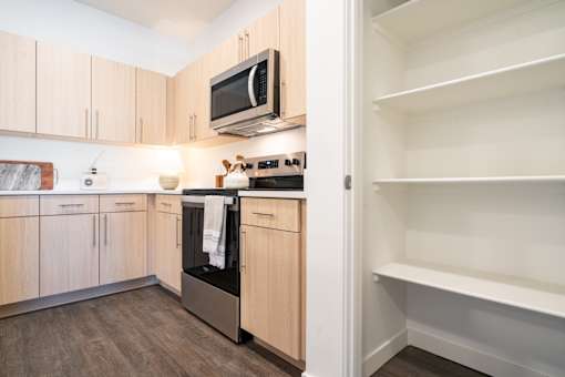 A kitchen with wooden cabinets and a microwave above the stove.at Copestone Apartments, Idaho