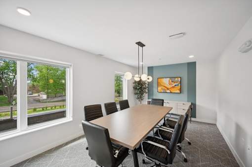 A conference room with a long table and chairs.