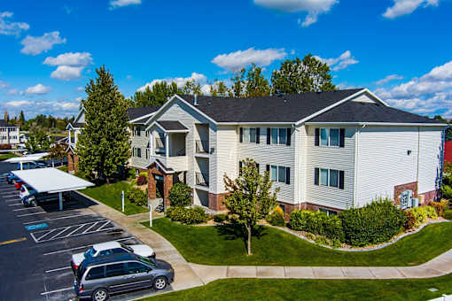 Eagles Landing apartment building with cars parked in reserved resident parking at Eagles Landing Apartments, Ammon, ID, 83406