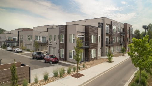a rendering of an apartment building with cars parked in a parking lot at Cycle Apartments, Fort Collins, Colorado