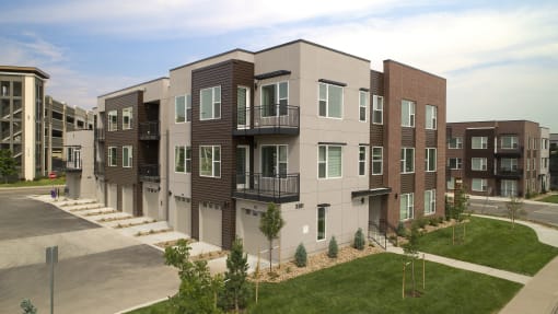 a rendering of a new apartment building with balconies and green grass at Cycle Apartments, Fort Collins, 80525