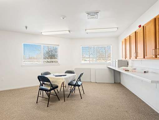 A room with a dining table and chairs.