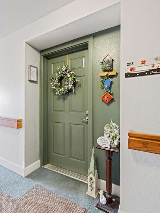 A green door with a wreath on it.
