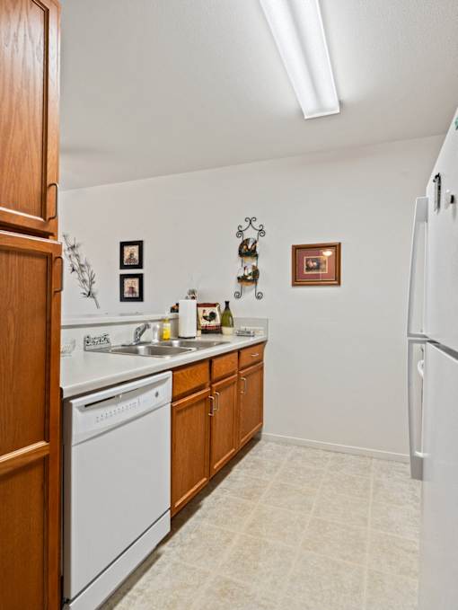 A kitchen with white appliances and wooden cabinets.