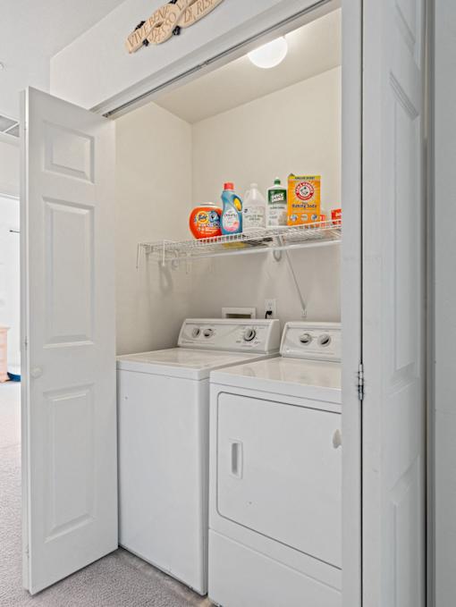A white laundry room with a washer and dryer.