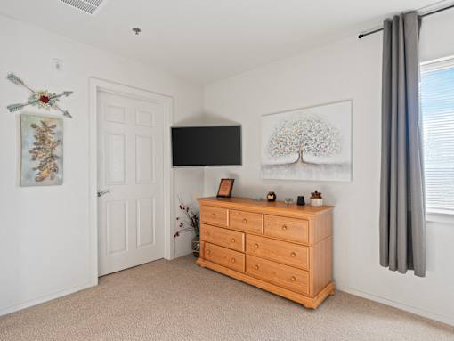 A room with a dresser and a painting on the wall.
