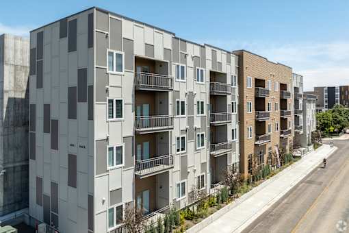 A row of modern apartment buildings with balconies and windows.