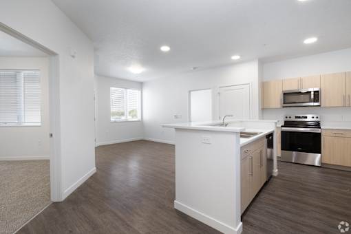 A kitchen with white appliances and wooden cabinets.