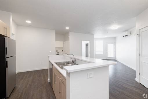 A kitchen with white cabinets and a stainless steel refrigerator.