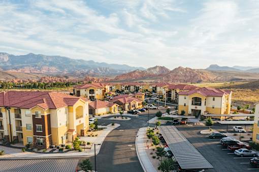 A view of a housing complex with a mountain range in the background.