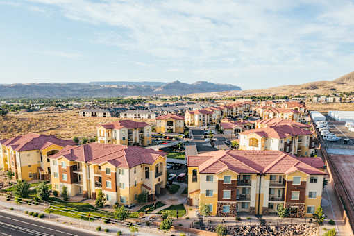 A large apartment complex with a parking lot in front.