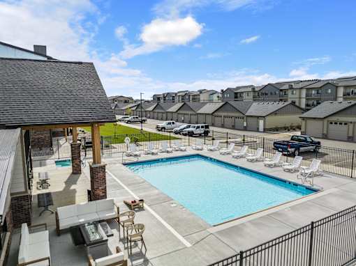 A swimming pool with lounge chairs and a fence in front of at The Expo in Billings, MT,