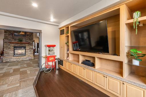A living room with a stone fireplace and a television. at Copper Run at Reserve, Montana