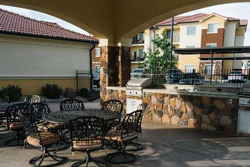 A patio with a table and chairs is in front of a building.