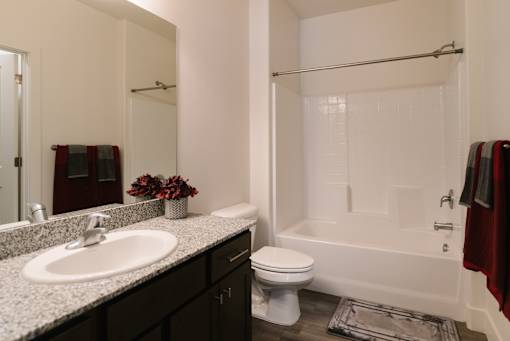 A white bathroom with a sink, toilet, and bathtub.